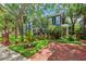 Two-story home with a brick driveway, mature trees, and manicured landscaping at 2404 W Jetton Ave, Tampa, FL 33629