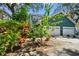 Exterior of home with two-car garage, lush landscaping, and paved driveway at 2404 W Jetton Ave, Tampa, FL 33629
