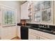 Bright kitchen featuring a black tiled counter, white cabinets, and a window with shutters at 2404 W Jetton Ave, Tampa, FL 33629