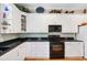 Bright kitchen with white cabinetry, modern appliances, and black tile countertops at 2404 W Jetton Ave, Tampa, FL 33629