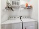 Laundry room with white washer and dryer, wire shelving, and ample storage space at 2404 W Jetton Ave, Tampa, FL 33629