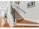 Staircase featuring hardwood steps, carpet runner, black iron railing, and natural light from a nearby window at 2404 W Jetton Ave, Tampa, FL 33629