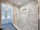 Modern bathroom featuring a tiled shower and luxurious soaking tub with chandelier at 2439 Madrid Ave, Safety Harbor, FL 34695