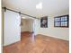 Bedroom showcasing tile flooring, sliding barn doors, and a window at 2439 Madrid Ave, Safety Harbor, FL 34695