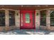 Elegant red front door with glass panels and sidelights, framed by brick and black sconces at 2439 Madrid Ave, Safety Harbor, FL 34695