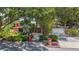 Charming single-story brick home featuring a red door, lush landscaping, and a well-manicured lawn at 2439 Madrid Ave, Safety Harbor, FL 34695