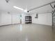 Spacious garage featuring painted flooring, storage shelves, and overhead lighting at 2439 Madrid Ave, Safety Harbor, FL 34695