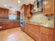 Kitchen features stainless steel appliances, granite countertops, wood cabinets, and a stone backsplash at 2439 Madrid Ave, Safety Harbor, FL 34695