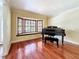 Elegant living room featuring gleaming hardwood floors, a bay window with shutters, and a piano at 2439 Madrid Ave, Safety Harbor, FL 34695