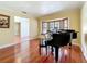 Living room boasts glossy wood floors, bay windows with shutters, and a grand piano at 2439 Madrid Ave, Safety Harbor, FL 34695