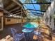 Pool area showcasing a screened enclosure, spacious wood decking, and charming patio furniture at 2439 Madrid Ave, Safety Harbor, FL 34695