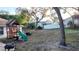 Expansive backyard features a play structure, mature trees, and ample space for outdoor activities at 270 Planter Rd, Spring Hill, FL 34606