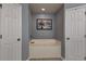 Neutral bathroom with a soaking tub framed by two doors, and a framed tree image at 270 Planter Rd, Spring Hill, FL 34606