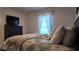 Comfortable bedroom featuring a TV and a window dressed with sheer curtains at 270 Planter Rd, Spring Hill, FL 34606