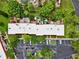 This is an aerial view of the condos featuring mature trees, assigned parking, and visitor parking at 2700 Bayshore Blvd # 544, Dunedin, FL 34698