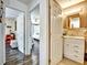 Bathroom with white vanity, decorative mirror, and a view of a bedroom with ceiling fan at 2700 Bayshore Blvd # 544, Dunedin, FL 34698