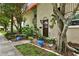 Charming townhome exterior showcasing landscaped front yard, mature trees and colorful flower pots at 2700 Bayshore Blvd # 544, Dunedin, FL 34698