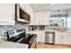 Bright kitchen featuring white cabinets, stainless steel appliances, and stylish tile backsplash at 2700 Bayshore Blvd # 544, Dunedin, FL 34698
