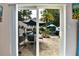 View of the private outdoor patio from inside the home, featuring a dining set and lush landscaping at 2700 Bayshore Blvd # 544, Dunedin, FL 34698