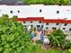 Aerial view highlighting the white roof, red trim, and various landscaped patios of the condos at 2700 Bayshore Blvd # 544, Dunedin, FL 34698