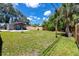 Large, grassy backyard featuring a covered patio, wood fence, and mature trees at 2859 38Th N Ave, St Petersburg, FL 33713