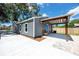 Home exterior with grey siding, wood accents, newer roof, and a spacious outdoor seating area at 2859 38Th N Ave, St Petersburg, FL 33713