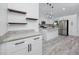 Modern kitchen featuring white cabinets, granite countertops, stainless steel appliances, and floating shelves at 2859 38Th N Ave, St Petersburg, FL 33713