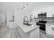 A modern kitchen features a granite island, stainless steel appliances, and modern light fixtures at 2859 38Th N Ave, St Petersburg, FL 33713