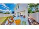 Relaxing outdoor patio with multiple seating areas and a view of the landscaped backyard and white fence at 2918 N 21St St, Tampa, FL 33605