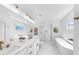 All-white bathroom with dual sinks, soaking tub, glass shower, and hexagon tile floor at 2918 N 21St St, Tampa, FL 33605