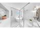 Sleek, all-white bathroom features a modern soaking tub and a seamless glass shower enclosure at 2918 N 21St St, Tampa, FL 33605