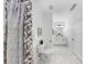 This bathroom features white hexagon tile flooring, a decorative shower curtain, and a vanity with double sinks at 2918 N 21St St, Tampa, FL 33605