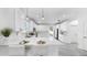 Modern, all-white kitchen featuring stainless steel appliances, quartz countertops, stylish pendant lighting, and seating at 2918 N 21St St, Tampa, FL 33605