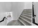 Stairway with gray tile risers and black railing, leading to the open-concept living area at 2918 N 21St St, Tampa, FL 33605