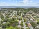 Expansive aerial view showcasing the property's location near a lake and a neighborhood with lush greenery at 3012 Grand View Ave, Clearwater, FL 33759