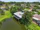 Aerial view of the property featuring a pond view, lush landscaping, and a spacious yard at 3012 Grand View Ave, Clearwater, FL 33759