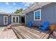 Inviting back patio with wooden deck, blue chairs, and outdoor relaxation space at 3012 Grand View Ave, Clearwater, FL 33759