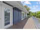 Spacious wooden back porch featuring serene lake views and white railings at 3012 Grand View Ave, Clearwater, FL 33759