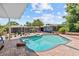 Backyard pool with stone accents, a spacious patio and mature trees at 3012 Grand View Ave, Clearwater, FL 33759