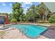 Backyard pool with stone accents, a spacious paver patio and stainless steel pool ladder at 3012 Grand View Ave, Clearwater, FL 33759