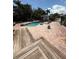 Beautiful backyard pool area with lush landscaping, a wooden deck, and brick pavers at 3012 Grand View Ave, Clearwater, FL 33759