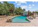 Backyard pool featuring a wood deck, stone accents, lush landscaping and a spacious paver patio at 3012 Grand View Ave, Clearwater, FL 33759
