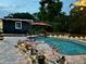 An amazing backyard pool with lush landscaping, poolside seating, and a spacious patio at 3012 Grand View Ave, Clearwater, FL 33759