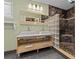 Bathroom features a double vanity, modern fixtures, and shower with black tile surround and glass block accent at 3012 Grand View Ave, Clearwater, FL 33759