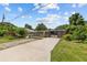 Long driveway leading to a beautifully landscaped home with mature trees and a gated entrance at 3012 Grand View Ave, Clearwater, FL 33759