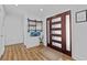 Welcoming foyer with modern wood door, stylish decor, and wood grain floors at 3012 Grand View Ave, Clearwater, FL 33759
