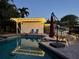 Backyard pool and patio area with lighting, covered area and privacy fencing at 3012 Grand View Ave, Clearwater, FL 33759