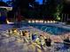A beautiful outdoor swimming pool lit up at night with decorative lighting and landscaping at 3012 Grand View Ave, Clearwater, FL 33759
