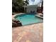 Outdoor swimming pool with a covered lounge area, rock waterfall, and tiled patio at 3012 Grand View Ave, Clearwater, FL 33759