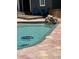 Outdoor swimming pool with patio and rock waterfall feature, with blue pool cleaning device at 3012 Grand View Ave, Clearwater, FL 33759